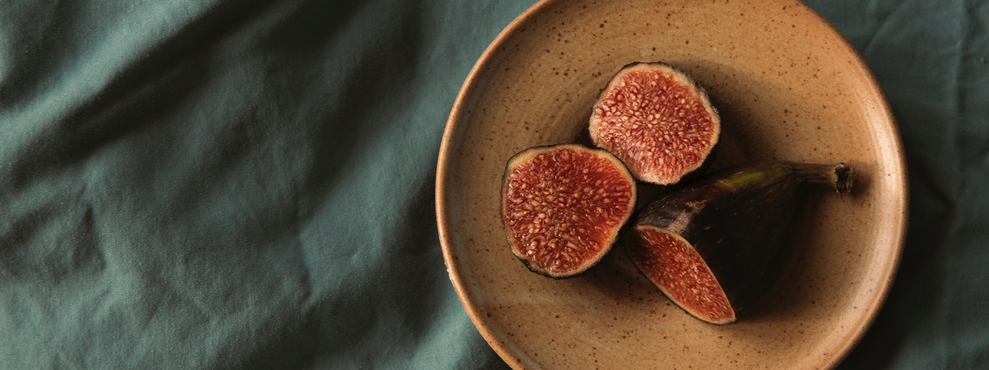 A plate of figs on a tablecloth